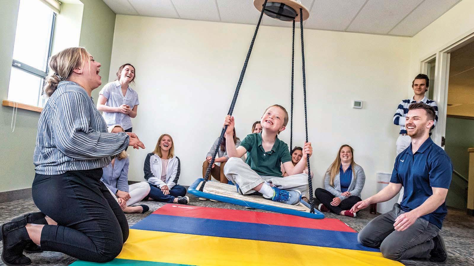 Smiling occupational therapy doctorate students working with child in the Billings clinic